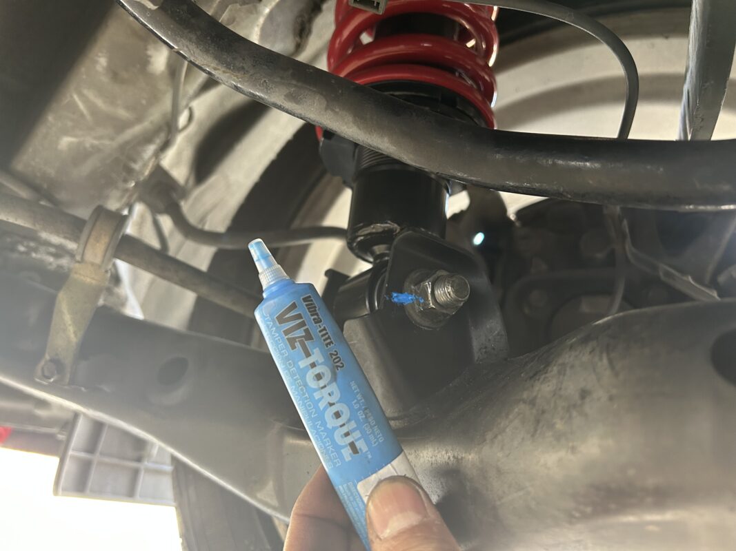 Marking lower strut bolts with vibratite paint