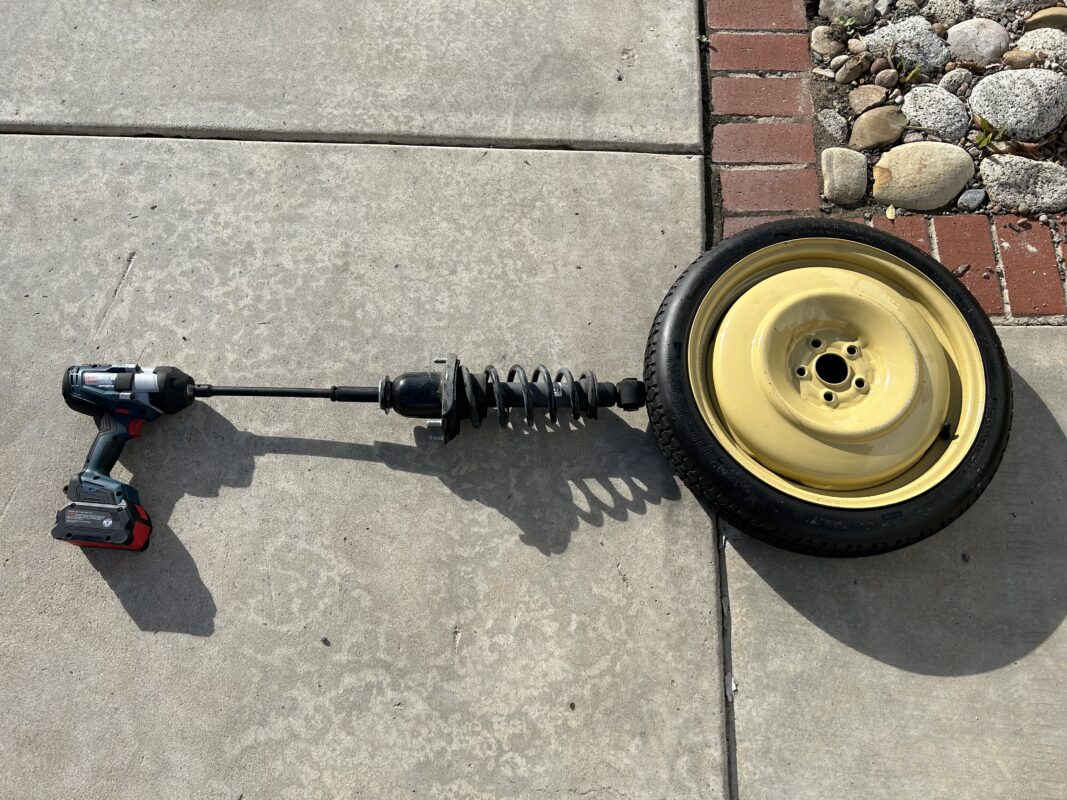 removing the rear strut shock hat bolt with caution